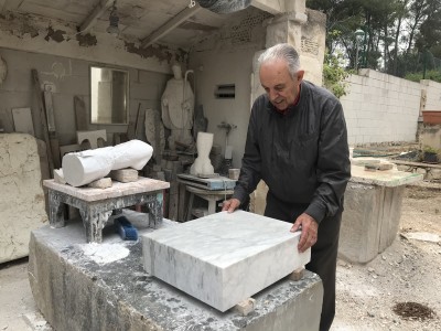 L'escultor Bruno Gallart treballant la peça de marbre amb què s'ha fet la reproducció de la pileta trilingüe. Foto: Museu Bíblic Tarraconense.